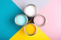 Four open cans of paint on bright symmetry background.