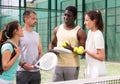 Four paddle tennis players talking on court Royalty Free Stock Photo