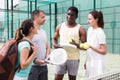 Four paddle tennis players talking on court Royalty Free Stock Photo