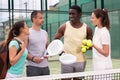 Four paddle tennis players talking on court Royalty Free Stock Photo