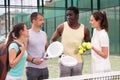 Four paddle tennis players talking on court Royalty Free Stock Photo