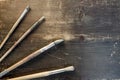 Four paint brushes laying ontop of a wooden background