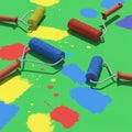 Four paint rollers with red handles lie on a bright green surface. Each roller is coated Royalty Free Stock Photo