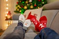 Four pair of feet in Christmas socks, mom and children lying on the couch, enjoying christmas time Royalty Free Stock Photo