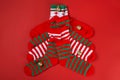 Four pairs of Christmas socks stacked like a Christmas tree and Christmas balls on top, on a red background Royalty Free Stock Photo