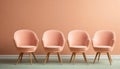 Four peach colored armchairs on wooden floor near peach colored wall. Color of the year 2024