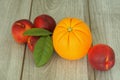 Four peaches and an orange with an unusual texture. Royalty Free Stock Photo