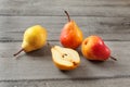 Four pears, one cut in half, on gray wood desk.