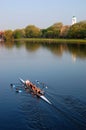 A four person coed scull team glides down the Charles River