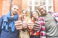 Four persons with different ethnicities showing thumbs up