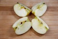 Four pieces of apple on wooden background Royalty Free Stock Photo