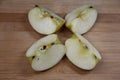 Four pieces of apple on wooden background Royalty Free Stock Photo