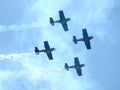 Four piston propeller aerobatic aicraft against sun. Royalty Free Stock Photo