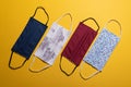 Four plain and patterned facemasks over yellow Royalty Free Stock Photo