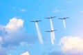 Four planes flying in formation leaving a white smoky trail among the clouds Royalty Free Stock Photo