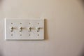 Four plastic light switches on wall set to on with copy space Royalty Free Stock Photo