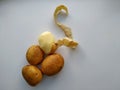 Four potatoes, one half peeled. isolated Royalty Free Stock Photo