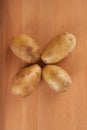 Four potatoes on wooden table Royalty Free Stock Photo