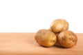 Four potatoes on wooden table Royalty Free Stock Photo