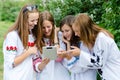 Four pretty happy teen girl friends and tablet computer Royalty Free Stock Photo