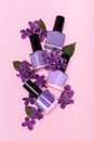 Four purple nail polish bottles on puple background. Set of purple nail polish bottles with purple lilac decoration
