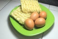 Four raw eggs and two raw instant noodles on a plate Royalty Free Stock Photo