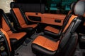 Four rear seats in a minibus are deployed to each other and tightened in black and brown leather with a diamond-shaped stitching