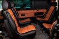 Four rear seats in a minibus are deployed to each other and tightened in black and brown leather with a diamond-shaped stitching