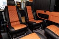 Four rear seats in a minibus are deployed to each other and tightened in black and brown leather with a diamond-shaped stitching