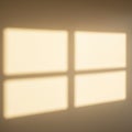 Four rectangular light patches create a window-like shadow on a beige wall. The soft, Royalty Free Stock Photo