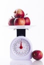 Four red apples on weighing scales portrait format
