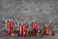 Four red burning wax advent candles on wooden natural grey background. Royalty Free Stock Photo