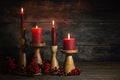 Four red candles in wooden candle sticks in a row as Advent or Christmas decoration against a dark rustic background, natural Royalty Free Stock Photo