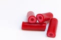 Four red candy pieces that are oblong and taste raspberry