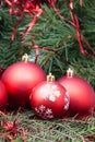 Four red Christmas balls and Xmas tree background Royalty Free Stock Photo