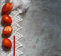 Four red easter eggs on a lacy napkin on a gray background, horizontal orientation, top view