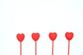 Four red heart shaped candles in a row isolated on white background. Royalty Free Stock Photo