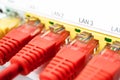 Four red patch cords are inserted in a white router. Internet connection