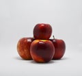 Four red, ripe apples stacked in a pyramid on a white background Royalty Free Stock Photo