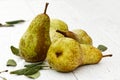 Four abate fetel pears with leaves on white painted wood.