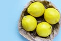 Four ripe lemon close-up on mint blue background. Group of fresh lemon in recycling paper bag. Royalty Free Stock Photo