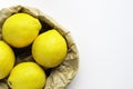 Four ripe lemon on white - grey background. Group of fresh lemon in recycling paper bag. Royalty Free Stock Photo