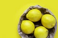 Four ripe lemon on yellow background. Group of fresh lemon in recycling paper bag. Eco packing concept Royalty Free Stock Photo