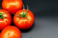 Four ripe red and juicy tomatoes lie on a black background Royalty Free Stock Photo