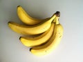 Four riped yellow bananas in white bakground