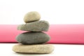 Four stacked river rocks with pink yoga mat Royalty Free Stock Photo