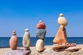 Four Rock zen pyramids of colorful pebbles standing on the beach, on the background of the sea. Concept of balance