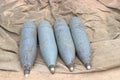 Four rusty artillery shells on sand Royalty Free Stock Photo