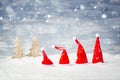 Four Santa Christmas hats in front of snow stars and trees