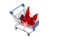 Four santa claus caps in a souvenir shopping trolley. Isolated object on white. New Year concept for design family Christmas